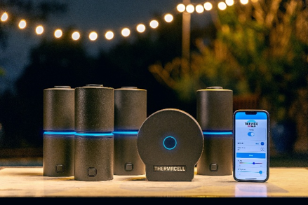 Thermacell LIV 2.0 hub, repellers, and app on a backyard patio at dusk